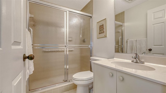 bathroom featuring vanity, a textured ceiling, tile patterned flooring, toilet, and a shower with shower door