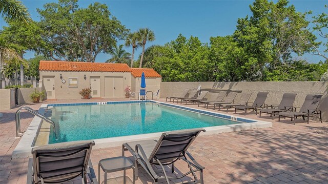 view of swimming pool with an outdoor structure and a patio area