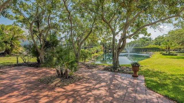 view of community featuring a lawn and a water view