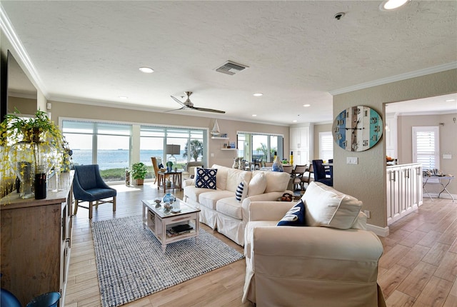 living room with light wood-type flooring, a water view, ceiling fan, and crown molding