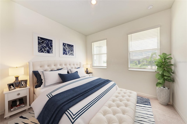 bedroom featuring light carpet and multiple windows