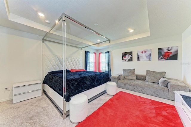 carpeted bedroom featuring a raised ceiling