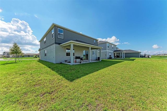 rear view of house featuring a patio and a yard