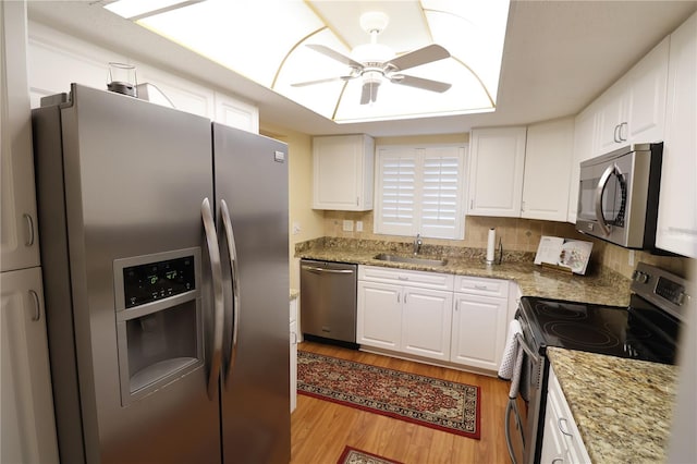 kitchen with ceiling fan, white cabinets, appliances with stainless steel finishes, and sink