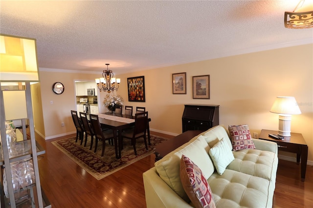 dining space featuring ornamental molding, wood-type flooring, a chandelier, and a textured ceiling