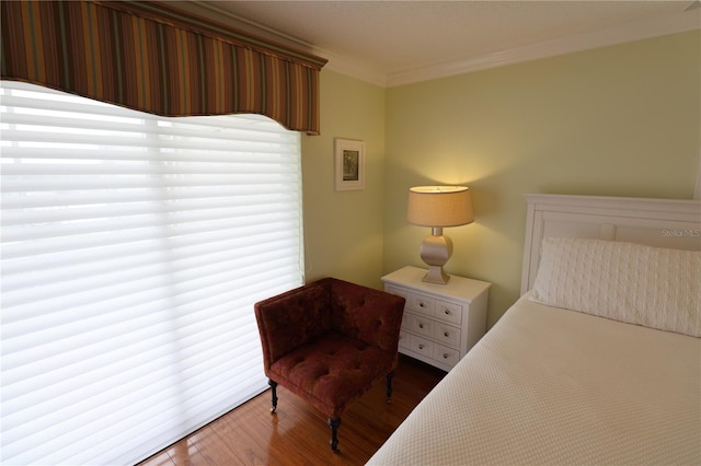 bedroom with wood-type flooring and ornamental molding