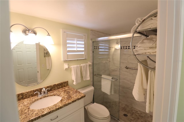 bathroom featuring vanity, toilet, and a shower with door