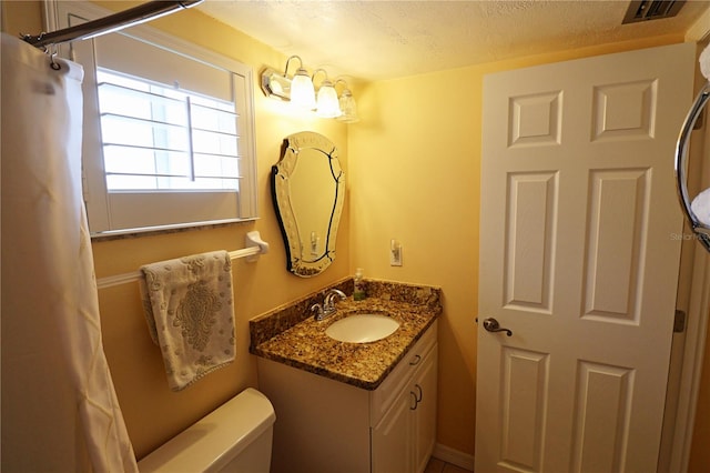 bathroom with a textured ceiling, vanity, toilet, and a shower with shower curtain