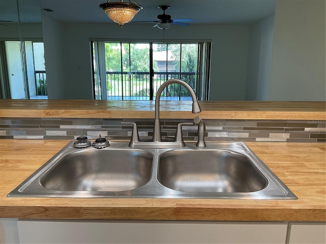 details featuring sink, ceiling fan, butcher block counters, and tasteful backsplash