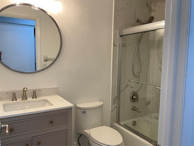 full bathroom featuring vanity, toilet, and bath / shower combo with glass door