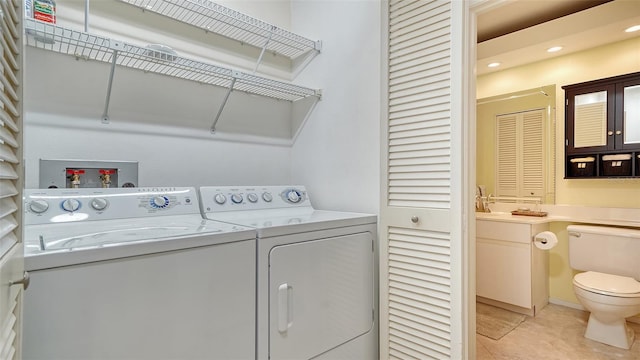 laundry room with light tile patterned floors and washing machine and clothes dryer