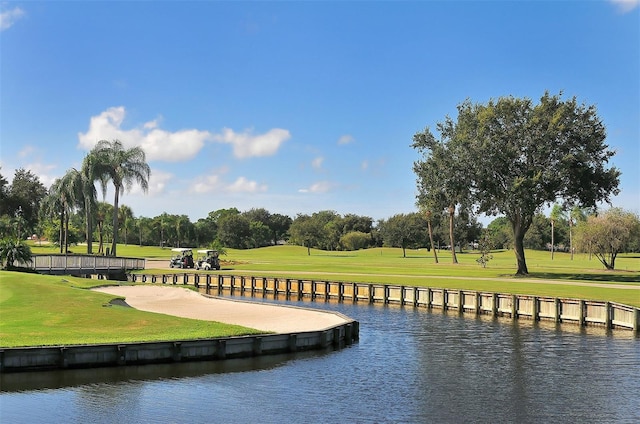 view of property's community with a lawn and a water view