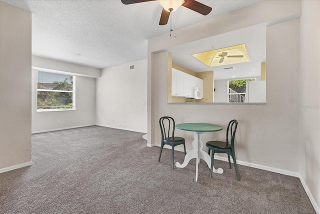 dining room with ceiling fan, carpet flooring, and a textured ceiling