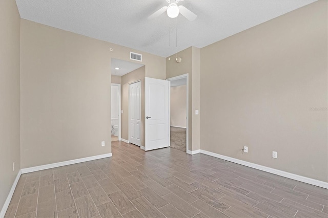 unfurnished bedroom featuring a closet, light hardwood / wood-style floors, ceiling fan, and a textured ceiling