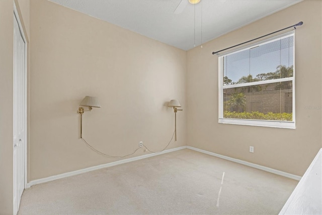 spare room featuring ceiling fan and light colored carpet