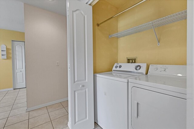 clothes washing area with washer and clothes dryer and light tile patterned floors