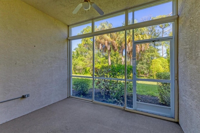 unfurnished sunroom with ceiling fan and plenty of natural light