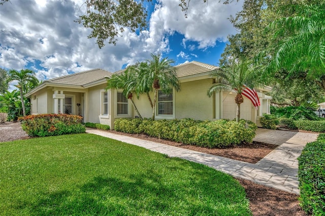 view of front of property featuring a front lawn and a garage