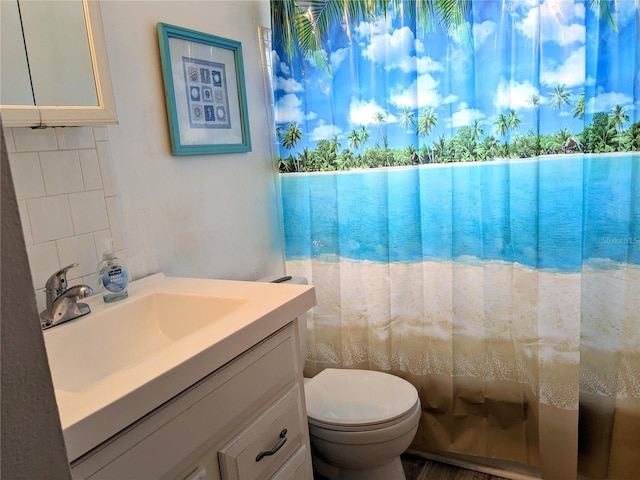 bathroom featuring toilet, tasteful backsplash, and vanity