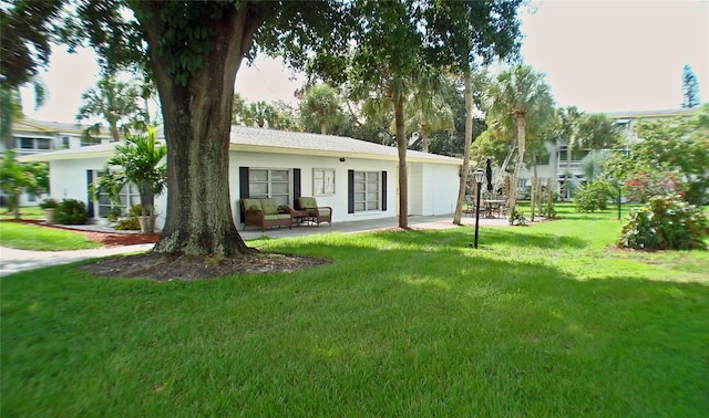 view of front of home with a patio and a front yard