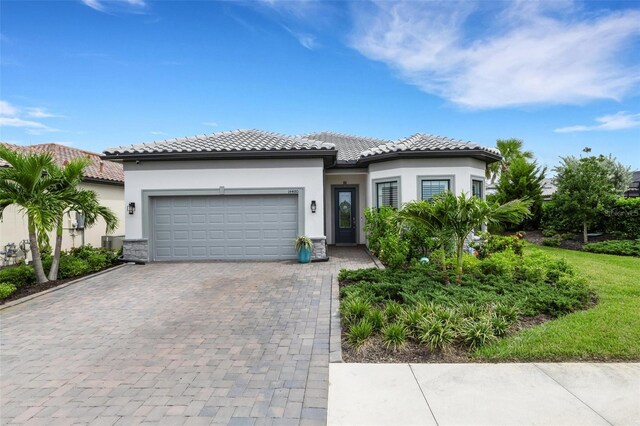 mediterranean / spanish-style home with central AC unit and a garage