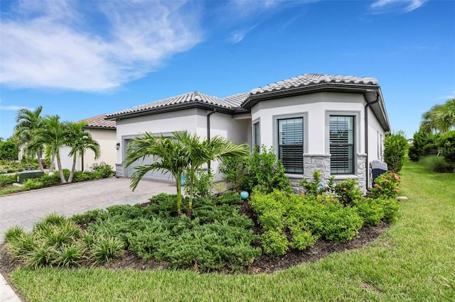 mediterranean / spanish-style home with a garage and a front lawn