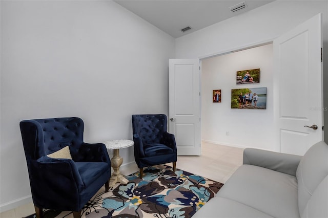 living area featuring baseboards and visible vents