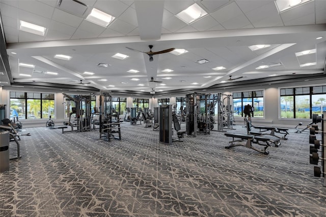 exercise room with a wealth of natural light, ceiling fan, and carpet flooring