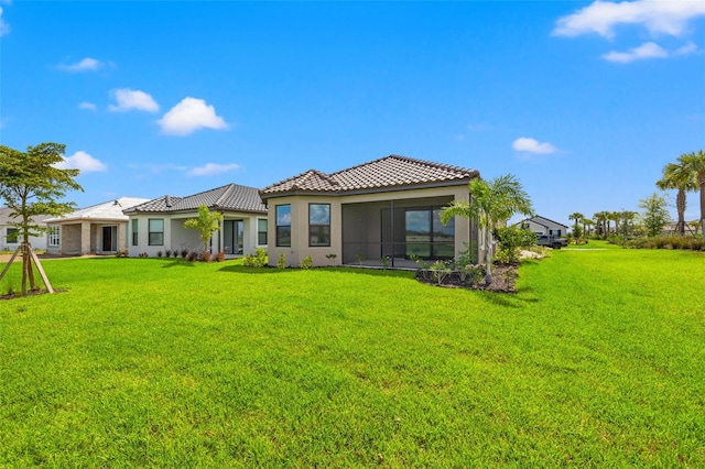 rear view of property featuring a lawn