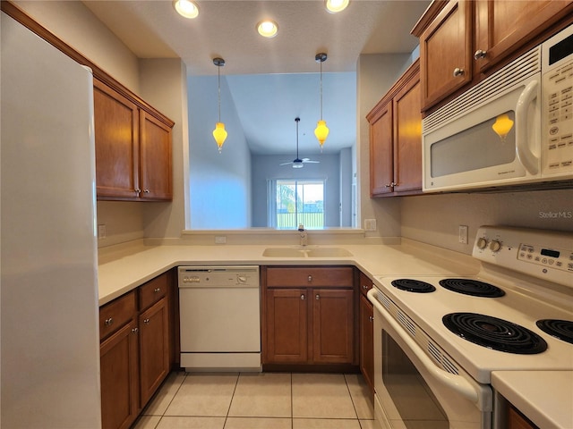 kitchen with ceiling fan, pendant lighting, light tile patterned floors, sink, and white appliances