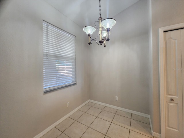 unfurnished dining area with an inviting chandelier and light tile patterned flooring