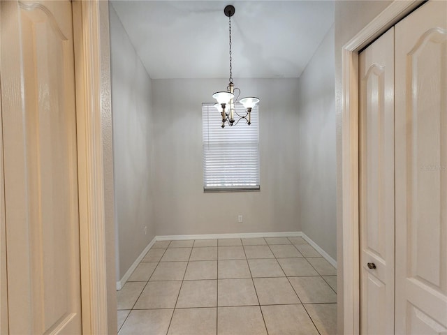 spare room with light tile patterned floors and a chandelier