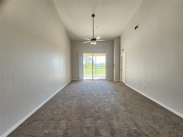 empty room featuring ceiling fan, carpet flooring, and high vaulted ceiling