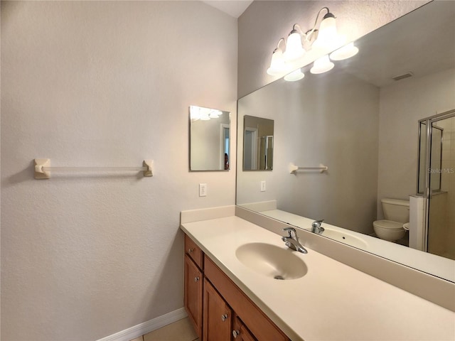 bathroom featuring vanity, a shower with shower door, and toilet