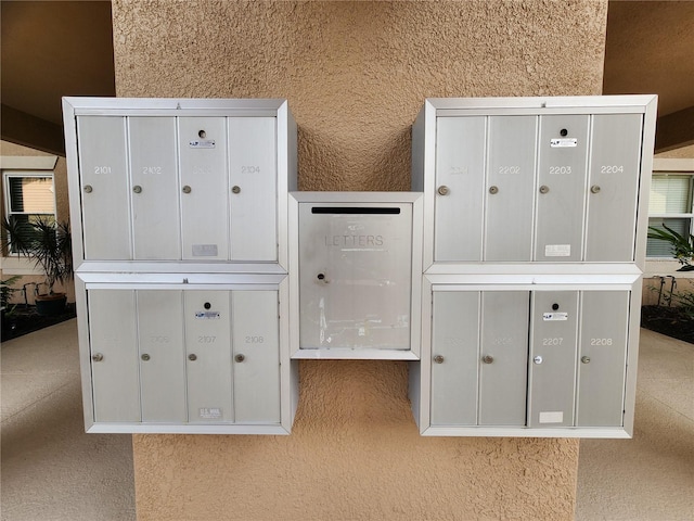 interior space with white cabinetry, a mail area, and light carpet