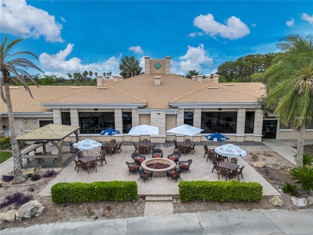 rear view of house with a fire pit, a gazebo, and a patio area