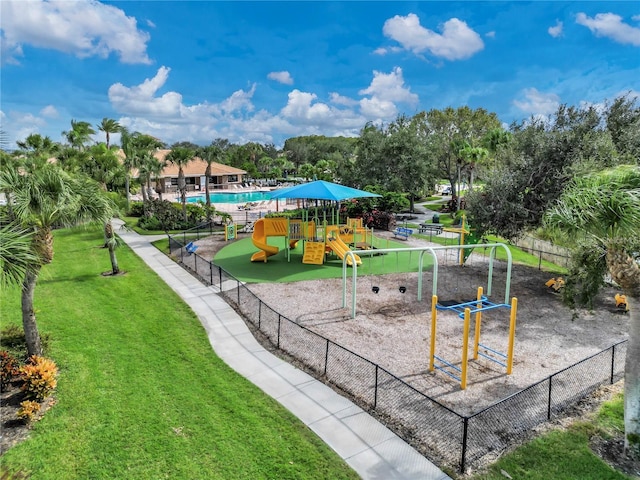 view of jungle gym featuring a community pool and a yard