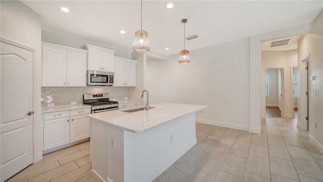 kitchen with a sink, visible vents, backsplash, white cabinets, and appliances with stainless steel finishes