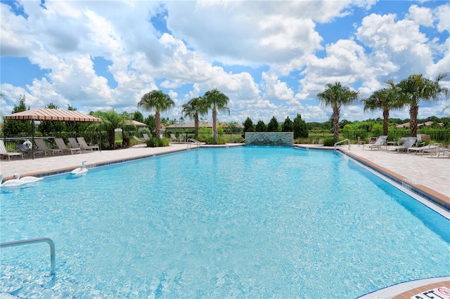 community pool with a patio and fence
