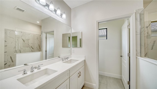 bathroom with visible vents, a sink, a walk in shower, and baseboards