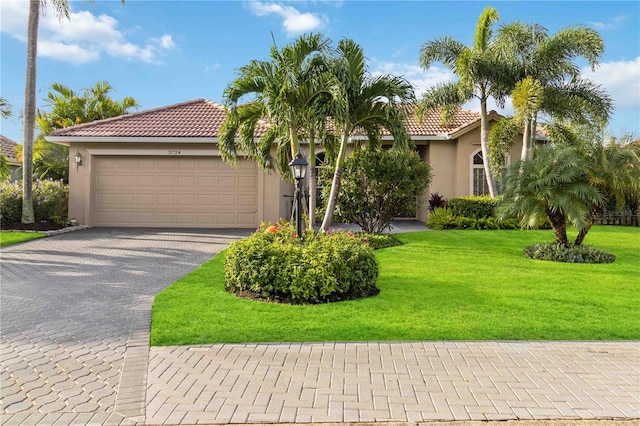 mediterranean / spanish-style house with a garage and a front lawn