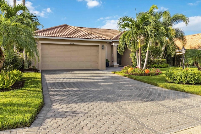 mediterranean / spanish-style house with a garage and a front lawn