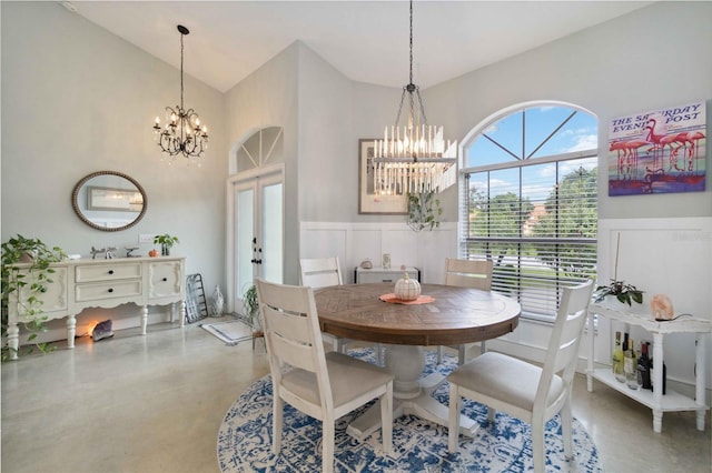 dining space with an inviting chandelier, concrete floors, and french doors