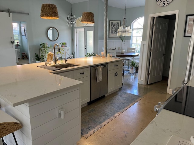 kitchen featuring pendant lighting, dishwasher, white cabinets, and an island with sink