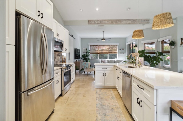 kitchen with pendant lighting, stainless steel appliances, a healthy amount of sunlight, and sink