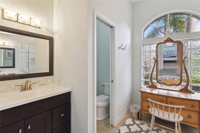 bathroom with walk in shower, vanity, and toilet