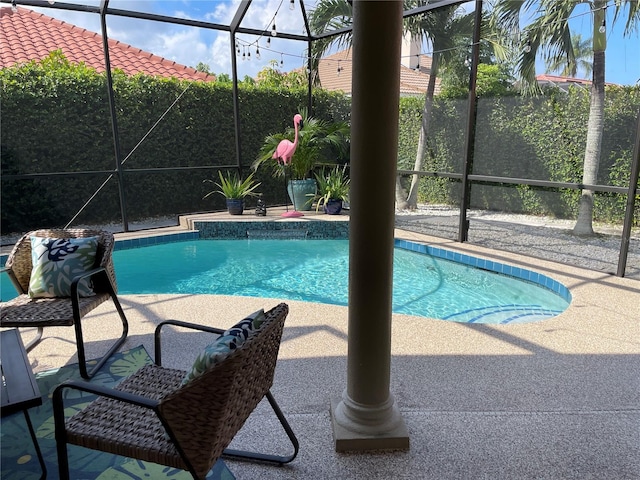 view of swimming pool featuring a patio and a lanai