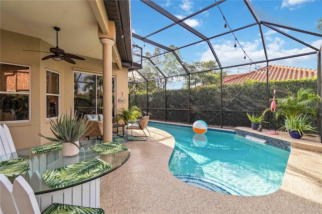 view of pool with glass enclosure, ceiling fan, and a patio area