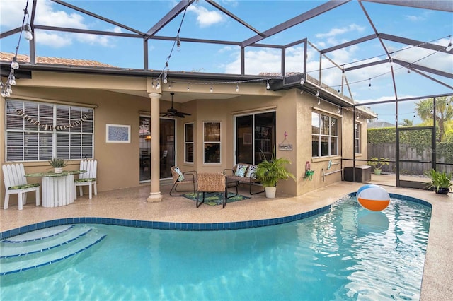 view of swimming pool featuring ceiling fan, glass enclosure, and a patio area