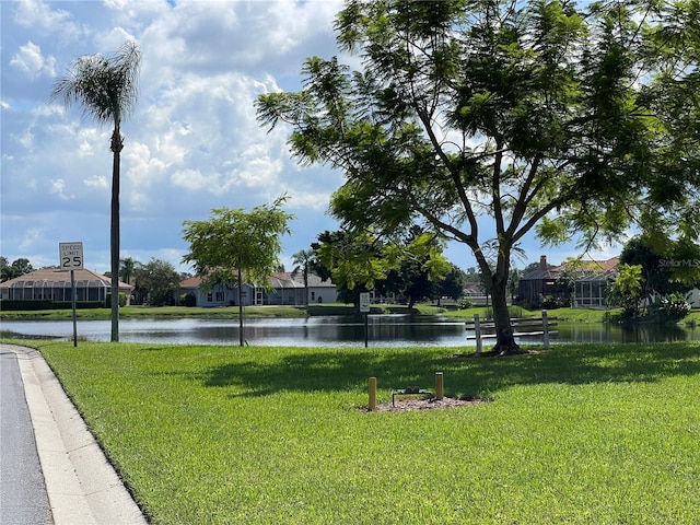 surrounding community featuring a lawn and a water view